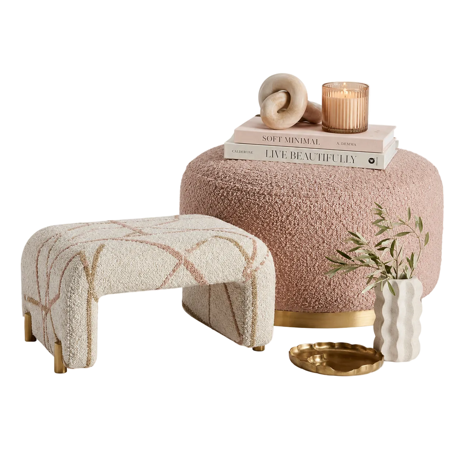 Two textured stools, a pink cushioned ottoman with decor items, on a white background